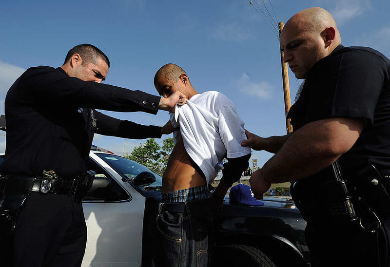 Полицейские Лос-Анджелеса обыскивают члена местной банды. Фото: Getty